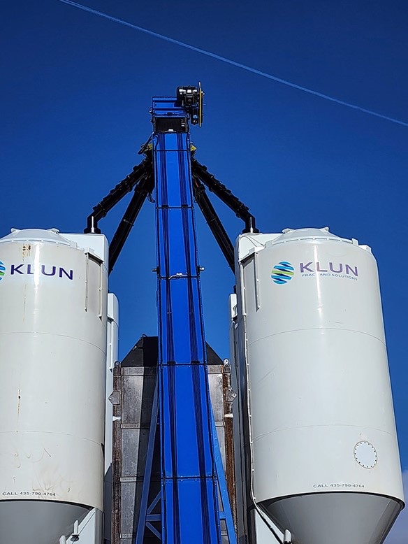 A steep fixed conveyor climbing between two storage silos